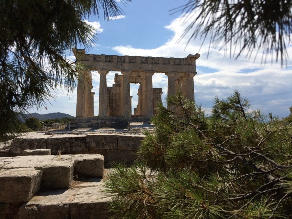 The Temple of Aphaia on Aegina. The temple is a house for this lesser known goddess, with a large outside altar for worship. On a clear day one can view the Acropolis in Athens from here, potentially connecting the temples in a triangle with the Poseidon Temple. Photo by Grove Harris. The Temple of Aphaia on Aegina. The temple is a house for this lesser known goddess, with a large outside altar for worship. On a clear day one can view the Acropolis in Athens from here, potentially connecting the temples in a triangle with the Poseidon Temple. Photo by Grove Harris.